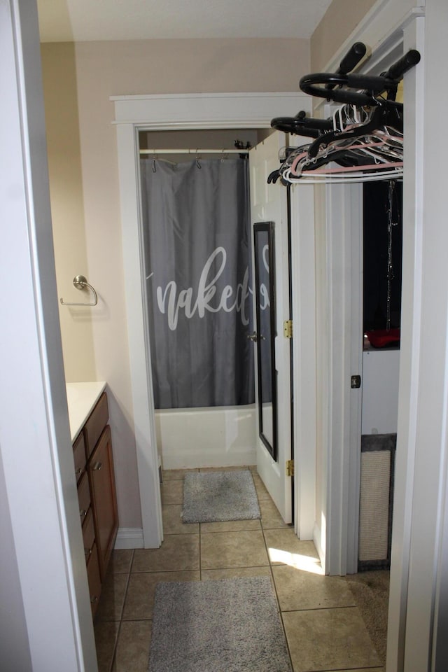 full bath featuring tile patterned floors, vanity, baseboards, and shower / bathtub combination with curtain