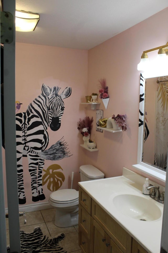 bathroom with toilet, vanity, and tile patterned flooring