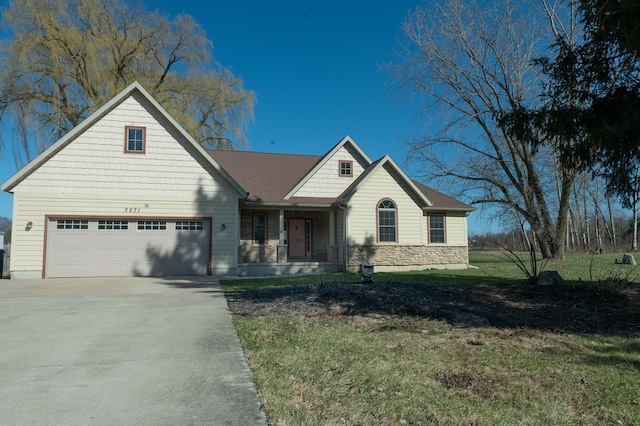 view of front of property featuring stone siding, a front yard, and driveway