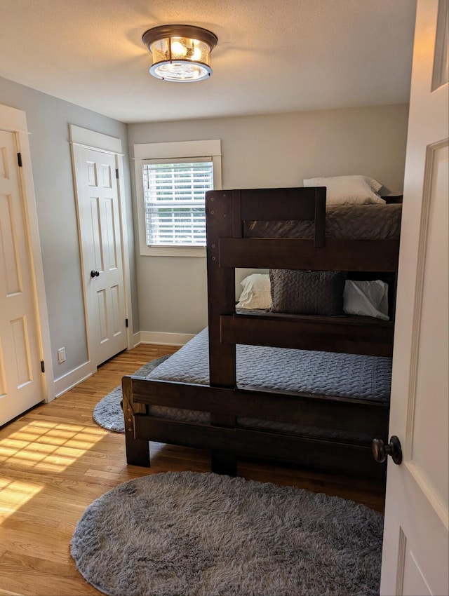 bedroom featuring baseboards and wood finished floors