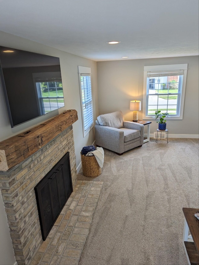 carpeted living area featuring a fireplace and baseboards