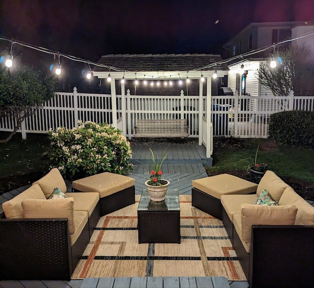 patio at twilight with outdoor lounge area and fence