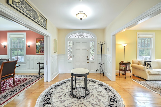 foyer with a wainscoted wall and light wood-style flooring