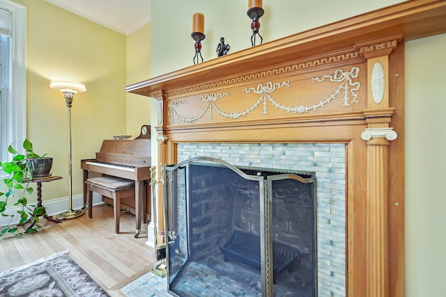 interior details with a fireplace, wood finished floors, baseboards, and ornamental molding