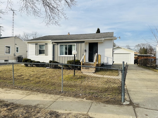 view of front of property featuring a fenced front yard, a garage, board and batten siding, and an outdoor structure