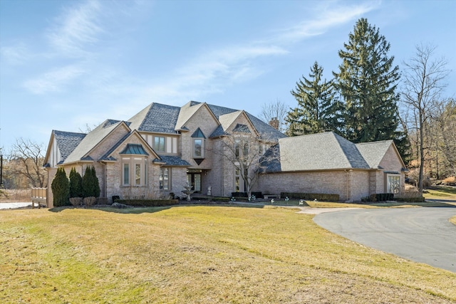 view of front of property with a front lawn, driveway, and a chimney