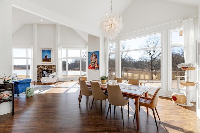 1265 Water Cliff Dr, Bloomfield Hills, MI 48302 - dining area with high vaulted ceiling, a high end fireplace, a chandelier, and wood finished floors