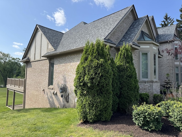 1265 Water Cliff Dr, Bloomfield Hills, MI 48302 - view of side of property featuring brick siding, a lawn, roof with shingles, and a deck