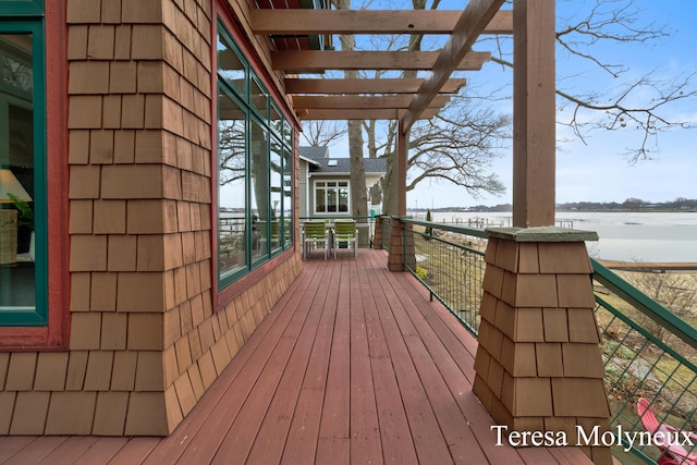 wooden deck with a water view and a pergola