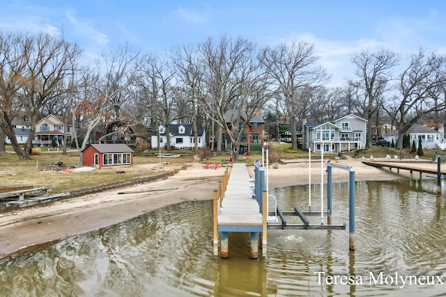 view of dock featuring a residential view, boat lift, and a water view