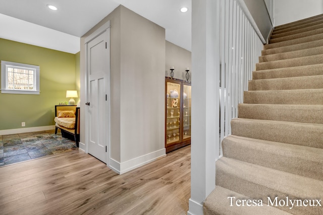 stairs with recessed lighting, baseboards, and wood finished floors