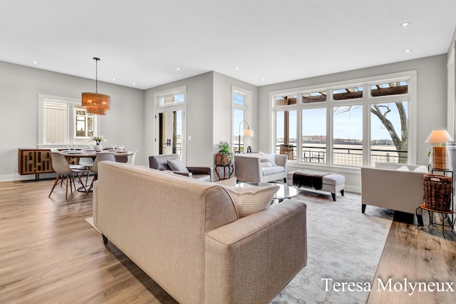 living room featuring recessed lighting, light wood-style floors, and baseboards