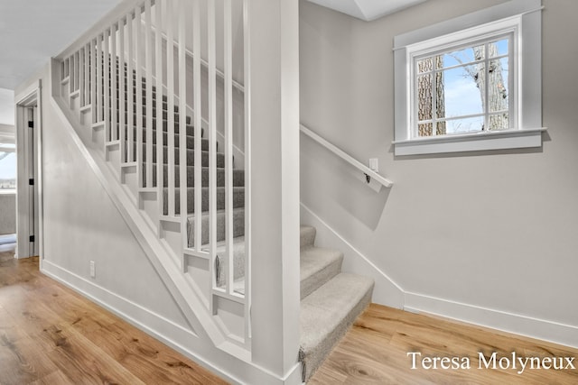 stairway with baseboards and wood finished floors