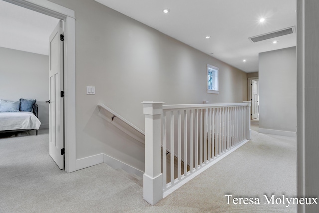 hall with recessed lighting, visible vents, an upstairs landing, and carpet