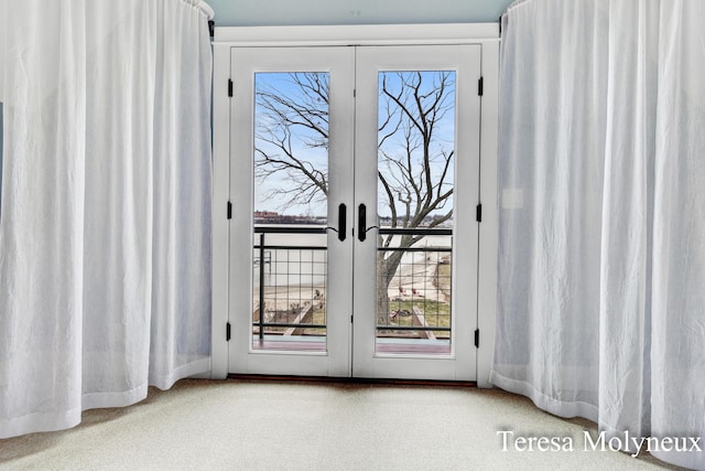 doorway to outside featuring french doors and carpet flooring