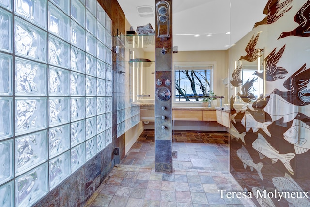 bathroom with vanity, walk in shower, and stone tile flooring