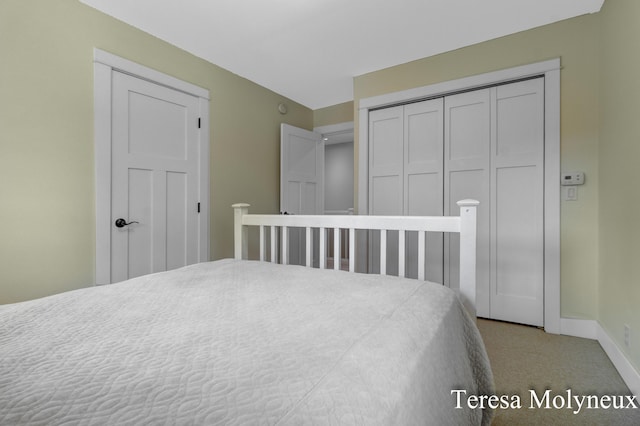 bedroom with a closet, baseboards, and carpet