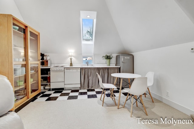 interior space with tile patterned floors, baseboards, and vaulted ceiling with skylight