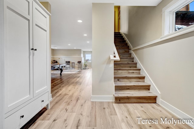 staircase featuring recessed lighting, wood finished floors, and baseboards