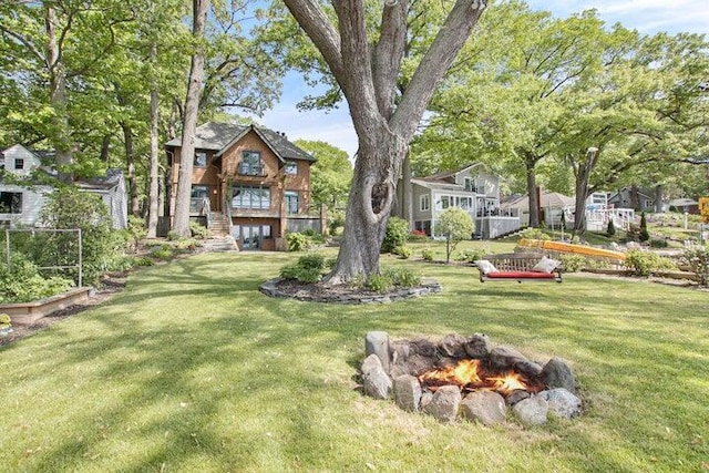 view of yard featuring a fire pit and stairs