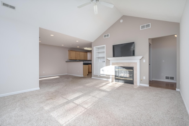 unfurnished living room featuring built in shelves, visible vents, and a tile fireplace