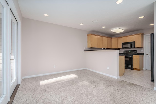 kitchen with dark countertops, light colored carpet, black appliances, and light brown cabinetry