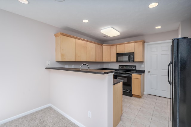 kitchen with dark countertops, light brown cabinets, black appliances, and a peninsula