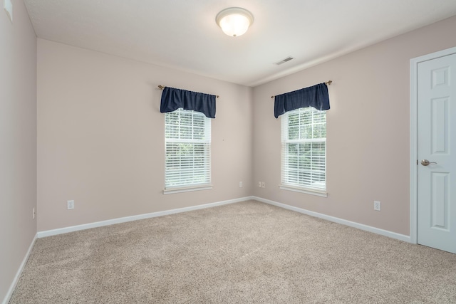 unfurnished room featuring visible vents, carpet floors, and baseboards