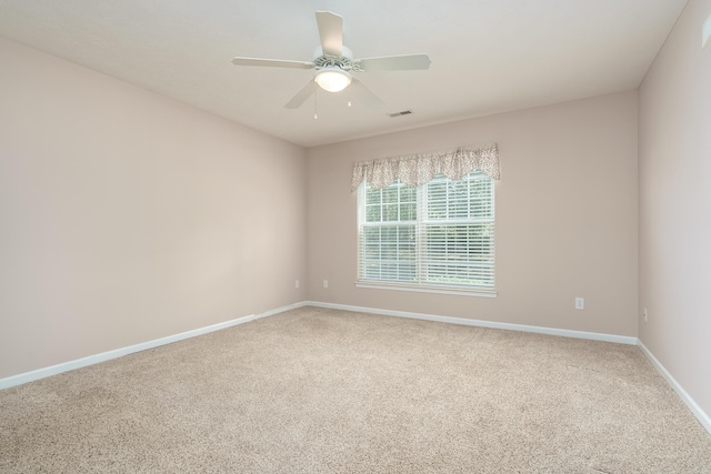 carpeted empty room featuring a ceiling fan, baseboards, and visible vents