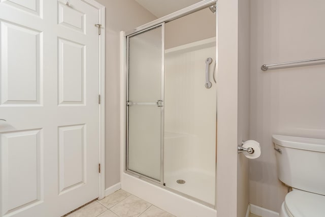 full bathroom featuring tile patterned flooring, a shower stall, and toilet