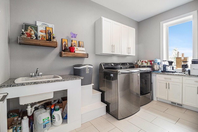 clothes washing area featuring a sink and washing machine and clothes dryer