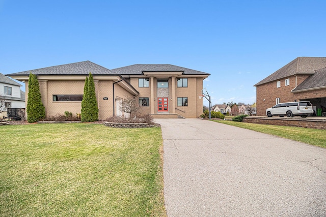 prairie-style house with aphalt driveway, french doors, and a front lawn