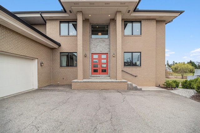 property entrance with a garage and brick siding