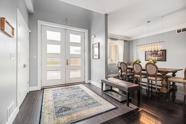 foyer entrance featuring french doors, baseboards, visible vents, and wood finished floors