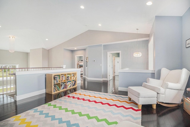 living area featuring wood-type flooring, baseboards, and lofted ceiling