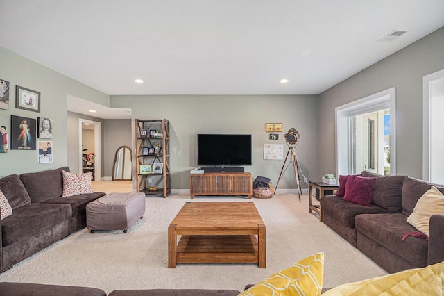 carpeted living area featuring recessed lighting, baseboards, and visible vents