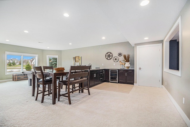 dining space featuring indoor bar, recessed lighting, beverage cooler, and light colored carpet