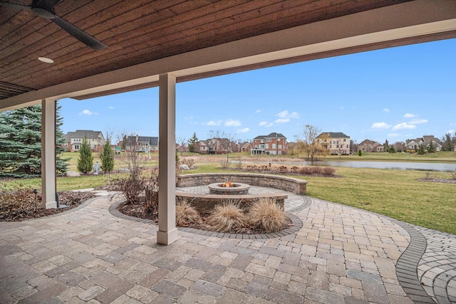 view of patio featuring a residential view, a water view, a fire pit, and ceiling fan