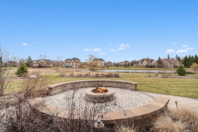 view of patio with a water view, a residential view, and a fire pit