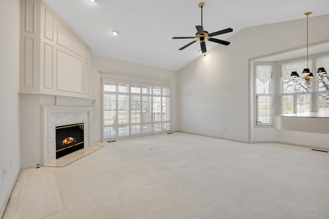 carpeted living area with visible vents, ceiling fan with notable chandelier, baseboards, a fireplace, and lofted ceiling