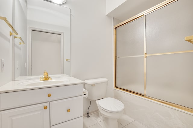 bathroom featuring tile patterned flooring, combined bath / shower with glass door, toilet, and vanity