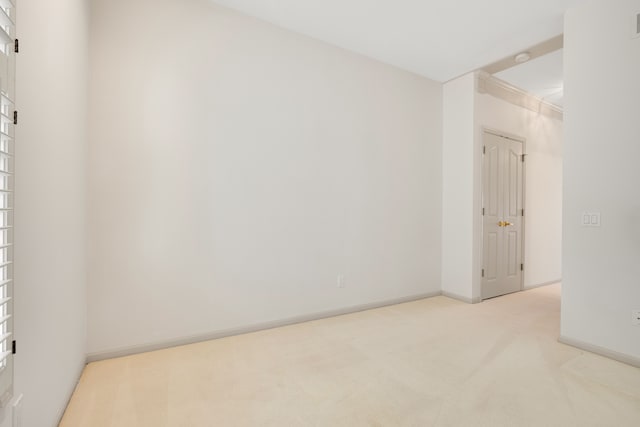 empty room with light colored carpet and baseboards