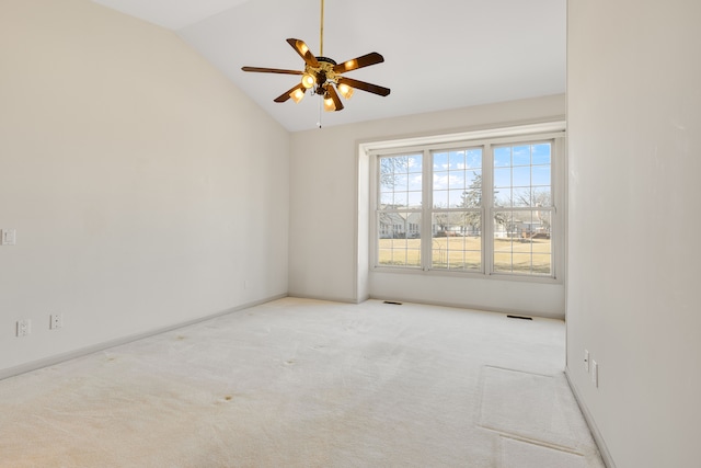 carpeted empty room featuring vaulted ceiling, visible vents, baseboards, and ceiling fan