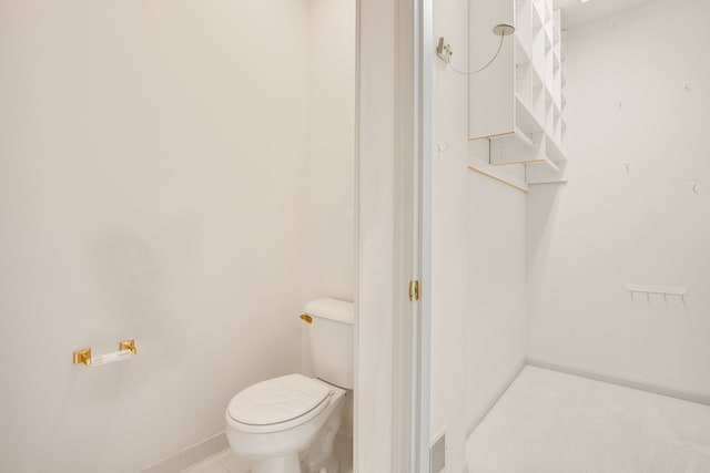 bathroom featuring baseboards and toilet