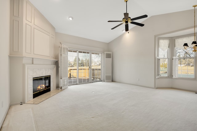 unfurnished living room featuring baseboards, vaulted ceiling, carpet flooring, a fireplace, and a ceiling fan