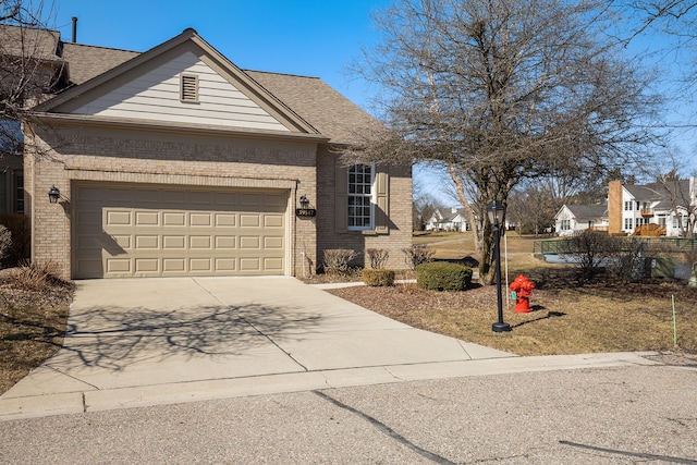 view of front facade featuring brick siding, an attached garage, driveway, and roof with shingles