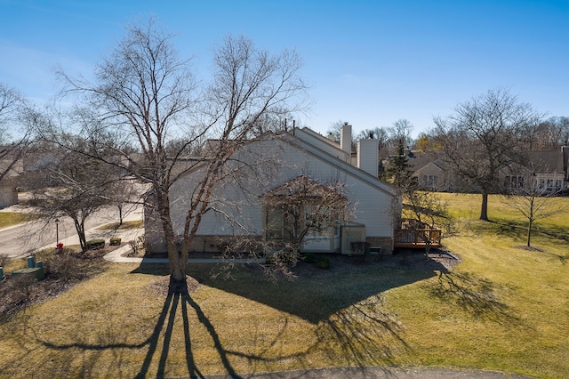 view of home's exterior featuring a lawn and a chimney