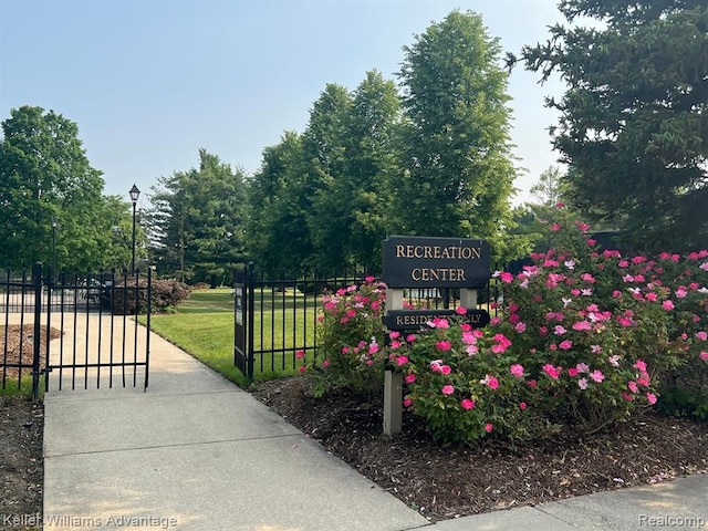 community sign featuring a gate and a yard