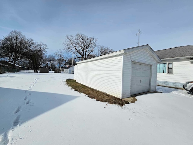 snow covered garage with a detached garage