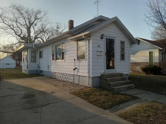 bungalow-style house with entry steps and a chimney